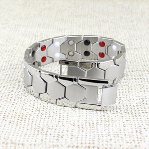 Macro shot of titanium steel bracelet showing magnetic therapy beads and silver hexagons