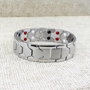 Macro view of silver magnetic therapy bracelet with hexagonal links and healing stones
