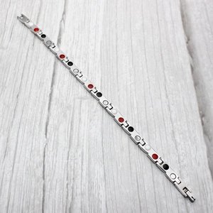 Close-up of magnetic health bracelet showing inlaid colorful therapy stones on inner band