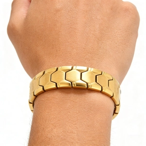 Détail d'un bracelet pour homme en acier titane doré aux maillons géométriques au poignet