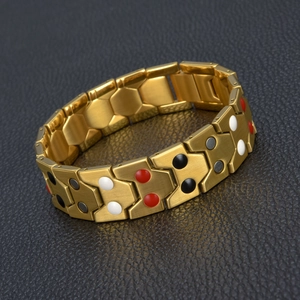 Détail du bracelet de magnétothérapie en acier titane doré avec pierres sur fond en cuir