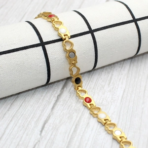Detail of gold magnetic therapy bracelet featuring multi-colored circular heart links