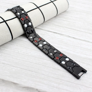 Détail macro d'un bracelet magnétique en acier inoxydable noir avec billes fonctionnelles