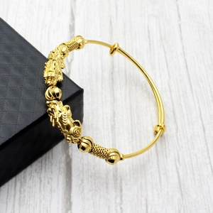 Detailed close-up of 18k gold plated bracelet featuring intricate dragon carving and texture
