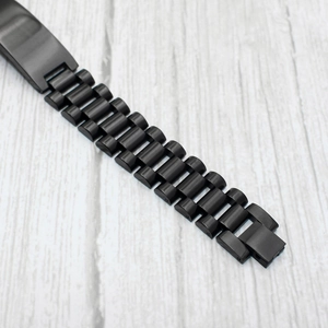 Detail view of the black matte stainless steel watch band with classic triple-link design