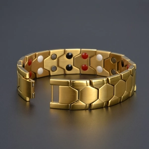 Détail du bracelet magnétique doré avec maillons hexagonaux et pierres colorées