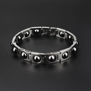 Dettaglio macro del bracciale da uomo in acciaio titanio con finitura spazzolata e perline