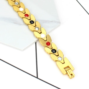 Détail du bracelet magnétique en acier titane doré 12mm avec maillons en V et inserts colorés