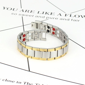 Detailed close-up of stainless steel magnetic bracelet with golden embossed textures