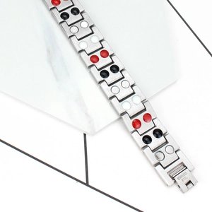 Close-up of silver magnetic therapy bracelet with stainless steel stamp and multi-color inserts