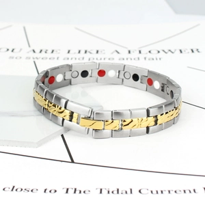 Detail eines silber-goldenen Magnettherapie-Armbands mit gravierten Gliedern und Magneten