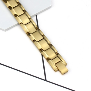 Détail macro du bracelet magnétique pour homme montrant les maillons en métal doré brossé