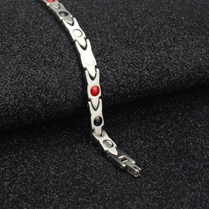 Macro shot of polished titanium magnetic therapy bracelet with tri-color health stones