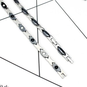 Detail of magnetic therapy necklace with black ceramic links and silver X-shaped steel parts