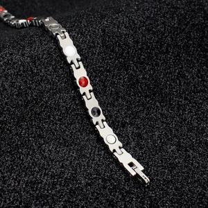 Dettaglio macro del bracciale in titanio argento con pietre magnetiche a quattro colori