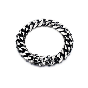 Macro shot of men's steel Cuban link bracelet featuring detailed gothic pattern engraving