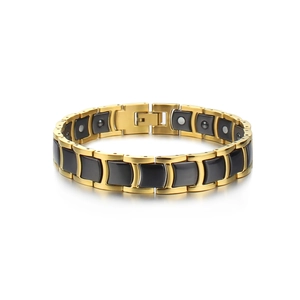 Macro detail of men's magnetic health bracelet with gold metal and black ceramic links