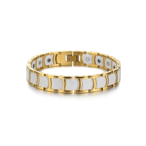 Detail of gold stainless steel and white ceramic magnetic therapy bracelet with fold-over clasp