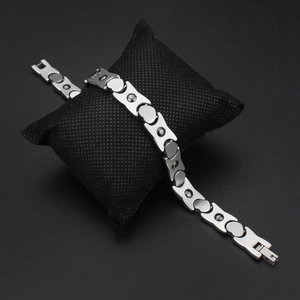 Bracciale magnetico in acciaio inossidabile argento lucido su cuscino da esposizione