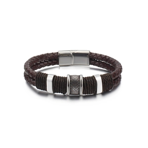 Detail of men's brown braided leather bracelet with textured steel rings and magnetic clasp