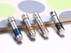 Detailed macro view of four cylindrical stainless steel perfume pendants with 'only' engraving