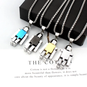 Détail de quatre pendentifs robots en acier inoxydable en finitions argent, or et noir