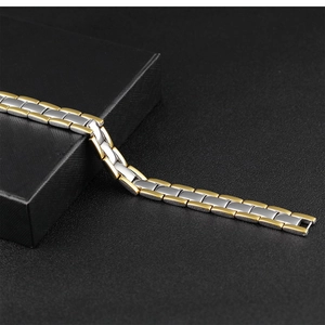Détail du bracelet en acier inoxydable bicolore or et argent sur un coffret à bijoux