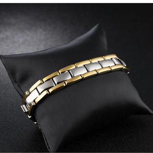 Détail du bracelet bicolore or et argent sur coussin de présentation en satin noir