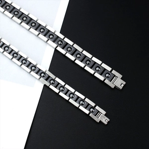 Detail of silver and black stainless steel magnetic therapy bracelets on contrast background