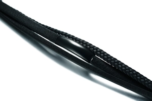 Détail macro d'un bracelet en cuir noir tressé multicouche avec curseurs métalliques