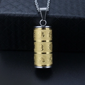 Macro shot of stainless steel cylinder pendant with engraved scriptures and lotus patterns