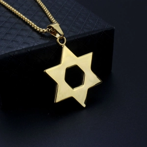 Gros plan du pendentif étoile de David doré posé sur un écrin à bijoux noir raffiné