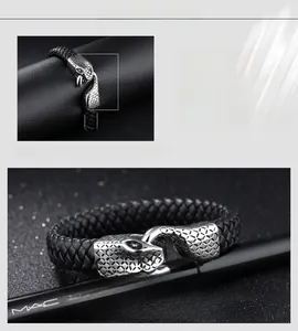 Detailed macro view of men's leather bracelet with a textured steel snake head clasp