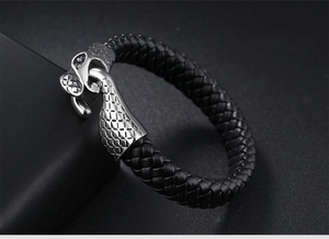 Macro detail of men's braided leather bracelet featuring a silver snake head hook clasp