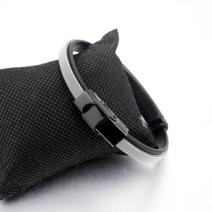 Mesh steel and black leather wrap bracelet with black metal clasp on display pillow