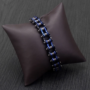 Industrial bike chain bracelet in blue and black stainless steel on leather cushion