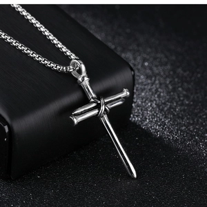 Détail macro du pendentif croix en clous d'acier style punk sur une chaîne box