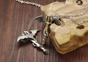 Detailed close-up of a gothic dragon wrapping around a golden sword pendant on wood