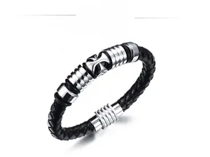 Macro detail of men's braided black leather bracelet with silver cross metal buckle