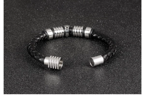 Detailed macro shot of men's braided leather bracelet with silver striped metal beads