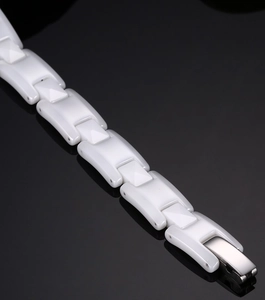 Macro view of white ceramic link bracelet with a polished silver metal folding clasp
