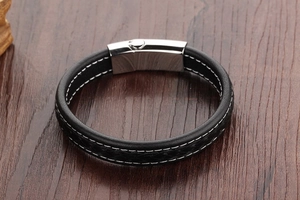 Detail of men's punk leather bracelet with white stitching and silver metal buckle