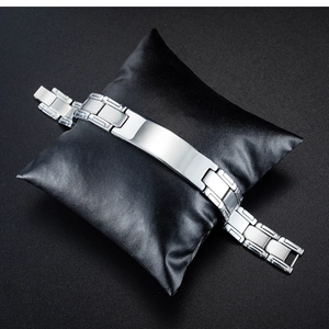 Close-up of men's stainless steel link bracelet with rectangular plate on black cushion