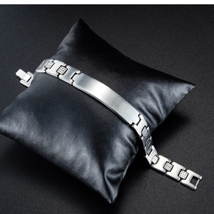 Close-up of silver stainless steel men's ID bracelet with brushed metal plate and textured links