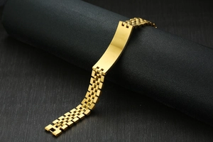 Vue macro d'un bracelet gourmette en acier doré avec plaque incurvée lisse à personnaliser