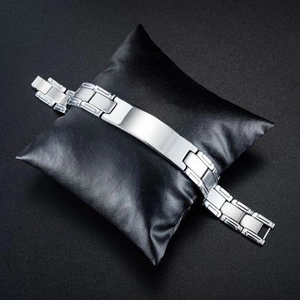 Polished silver stainless steel ID curb chain bracelet on a black leather cushion