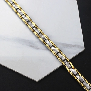 Détail du bracelet magnétique bicolore or et argent avec maillons en H texturés