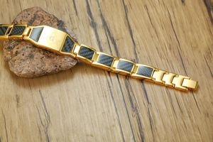 Détail du bracelet maçonnique plaqué or avec insert en fibre de carbone et logo compas
