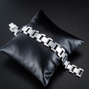 Bracelet en acier titane brossé argenté pour homme sur un présentoir en cuir noir