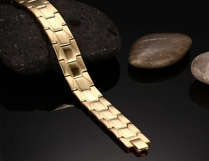 Nahaufnahme von goldenem Edelstahl-Armband im Uhrenstil mit spiegelpolierter Oberfläche